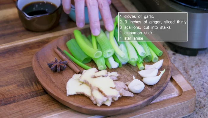 Add garlic, ginger, scallions, cinnamon stick, star anise, and seared ribs to the wok. Stir for 1 minute.