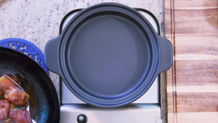 Transfer everything to a clay pot (or suitable alternative). Rinse the wok with 1 1/2 cups of water and add to the pot.