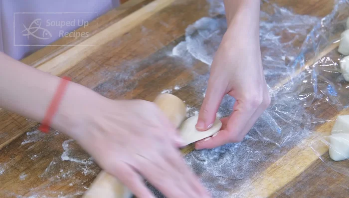 Assemble the dumplings: Roll out small dough pieces into thin wrappers. Add filling, pleat and seal tightly.