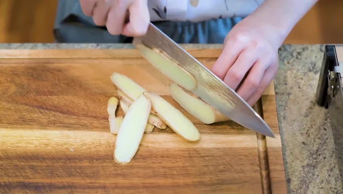 Slice ginger, halve garlic cloves (no need to peel yet), quarter shallots (remove outer layers), and tie two scallions into a knot.