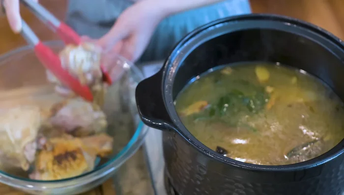 Remove chicken from the pot and let it cool. Discard aromatics and skim off excess chicken fat using an oil strainer.