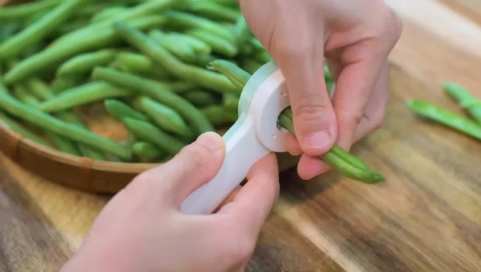 Cut the green beans open lengthwise to allow faster cooking and deeper seasoning infusion.