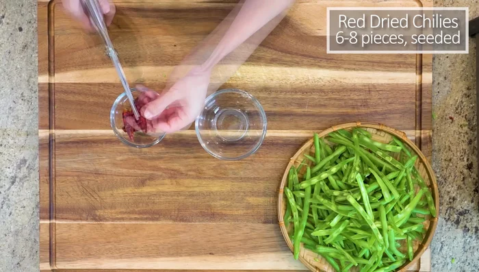 Cut open red dried chilies and discard the seeds. Set aside.