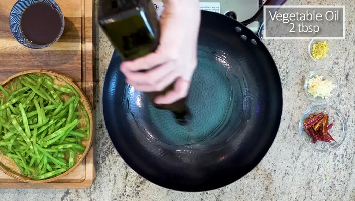 Heat oil in a pan over medium heat. Add red dried chilies, diced garlic, and ginger. Stir until fragrant (about 1 minute).