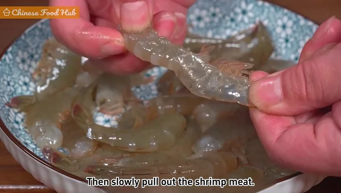 Peel frozen shrimp: Pinch the tail and gently pull out the shrimp meat to keep it whole.