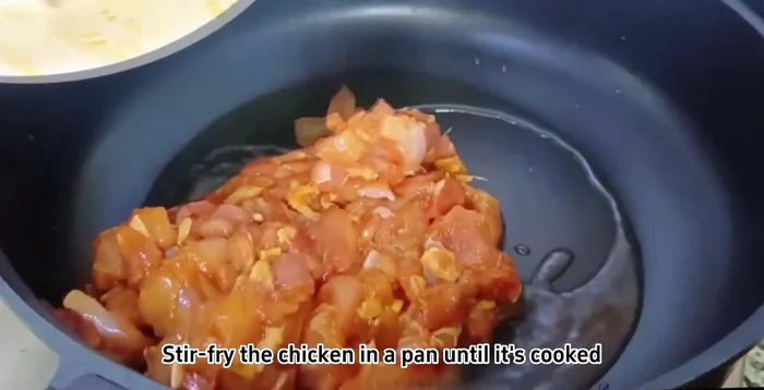 Stir-fry the marinated chicken until cooked.