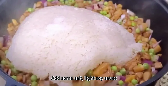 Add steamed glutinous rice, salt, light soy sauce, dark soy sauce, 13 spice blend, and chicken essence. Stir-fry everything together evenly.