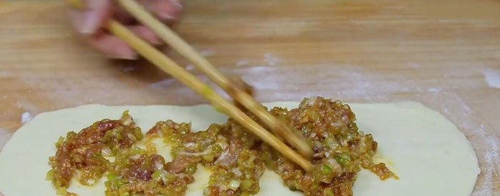 Assemble pancakes: Spread a portion of the meat filling evenly onto each dough circle. Fold from one side to the center, then fold the other side, pressing to seal and remove air. (221.159)