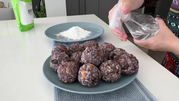 Lightly spray the balls with water, and roll them in glutinous rice flour until evenly coated. Repeat for a thicker coating.
