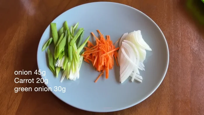 Cut up green onions, onions, and carrots. Stir-fry until softened and fragrant, then season with salt and pepper.
