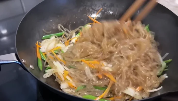 Add the cooked vermicelli noodles to the stir-fried vegetables and mix well. Let cool.