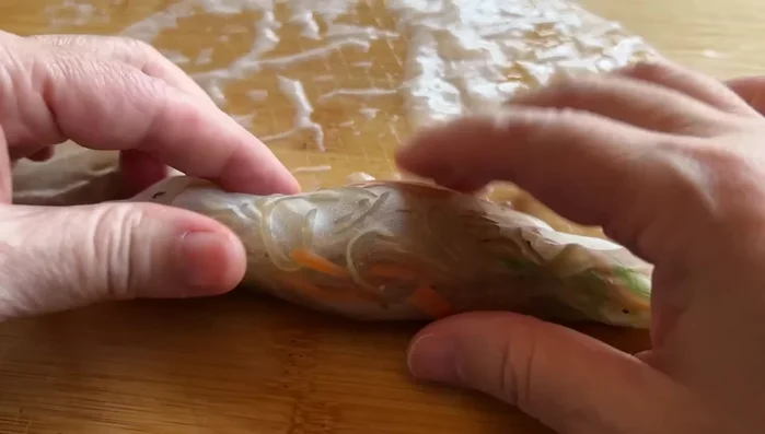 Layer the filling onto each rice paper sheet, roll tightly, tuck in the sides, and wrap in half a sheet of Nori.