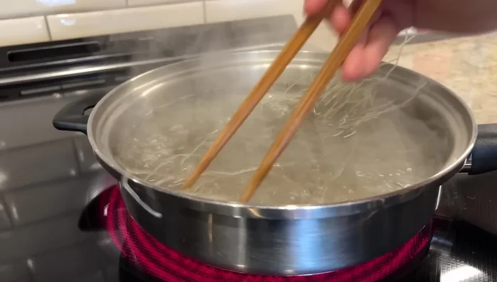 Cook vermicelli noodles in boiling water until soft. Rinse with cold water and season with coconut sugar, soy sauce, and sesame oil. Cut into smaller pieces.