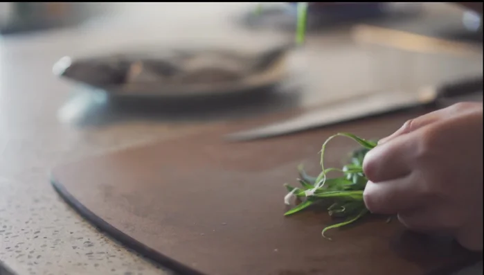 Prepare aromatics: Cut green onions and slice ginger. Tuck ginger slices and green onions into the fish's belly and along the sides.