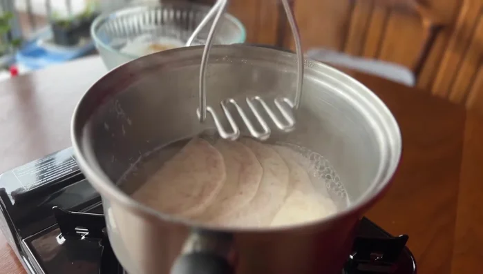 Mash the cooked taro with a potato masher, adding water as needed to achieve a smooth paste.