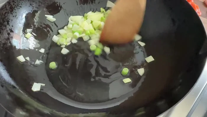 Push the sautéed onion and scallions to one side of the pan, add salmon and sear quickly. Do not overcook.