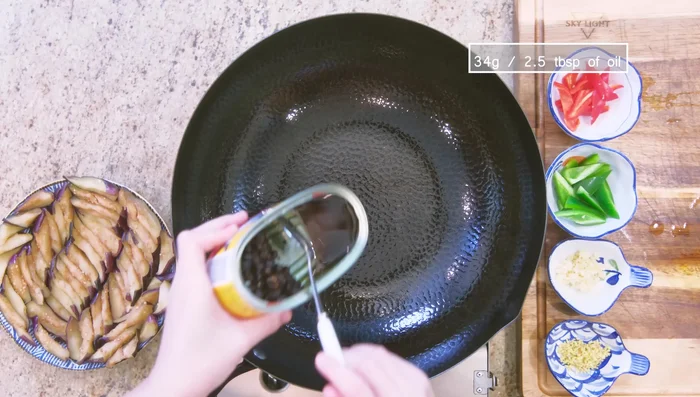 Preheat wok over medium heat. Add oil from dace can. Add eggplant and cook for 2 minutes.