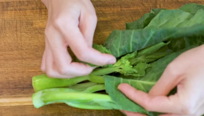 Dice Chinese broccoli stem into thin rounds. Separate leaves and stems.
