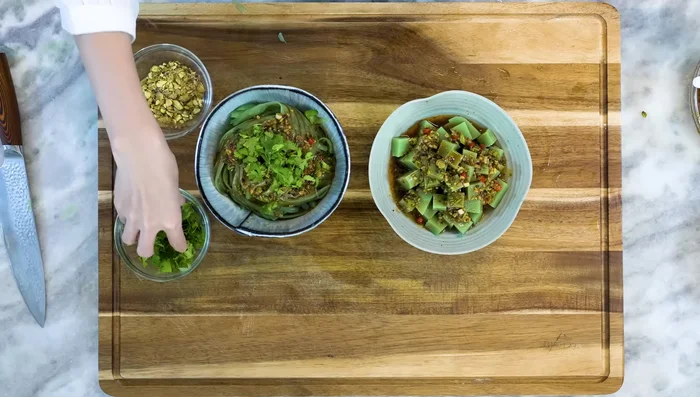 Drizzle the dressing over the noodles, garnish with cilantro and nuts (optional), and serve.