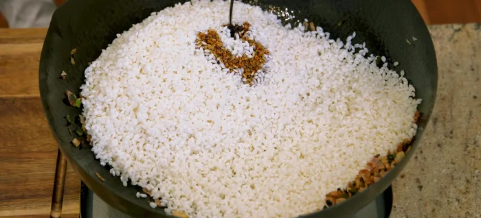 Add drained rice and dark soy sauce to the pan and stir until slightly sticky.