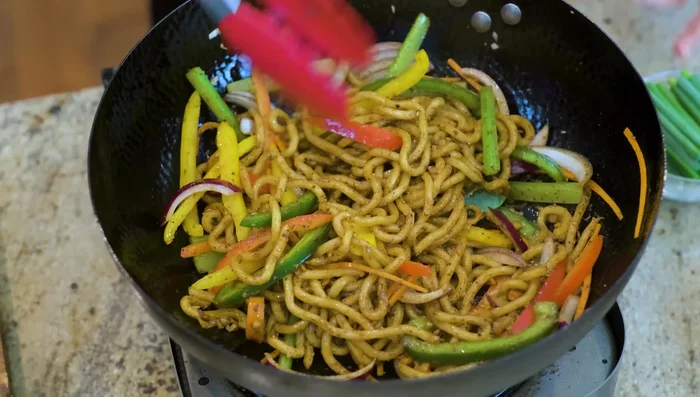 Add the cooked beef, scallions, and remaining vegetables to the wok. Mix until everything is well combined.