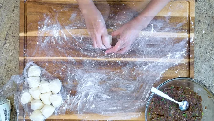 Assemble the buns: Roll out each dough piece to a 3-inch diameter circle. Add about 3 tablespoons of filling, pinch the edges to close.
