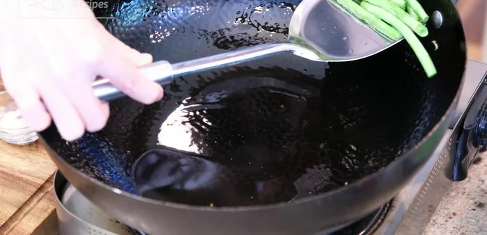 Remove yard beans from wok. Squeeze out excess moisture from salted eggplant, rinse, and squeeze again. Flip eggplant so the skin side faces down.