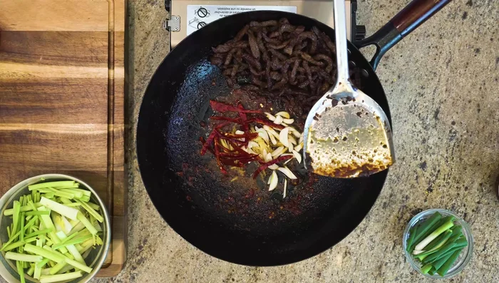 Add ginger strips, garlic slices, dried red chilies, and celery. Stir for a couple of minutes.
