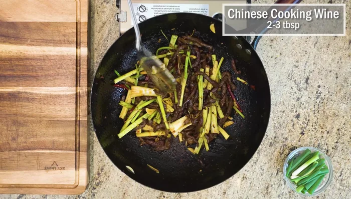 Add a few splashes of Chinese cooking wine around the sides of the wok. Mix everything together.