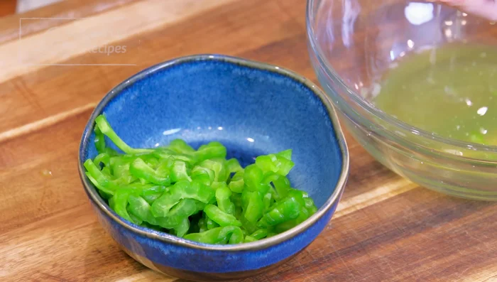 Squeeze the bitter melon to remove excess water. Heat a wok, add oil, toss in bitter melon and garlic, stir for 2 minutes.
