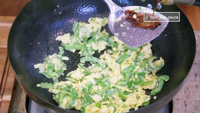 Add ground white pepper, soy sauce (drizzled from the side of the wok to caramelize). Stir well.