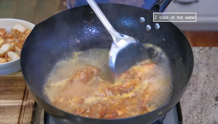 Pour in 2 cups of hot water, bring to a simmer, and cook for a few minutes. Remove the shrimp heads and shells.