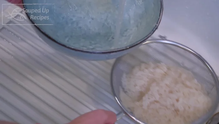 Wash rice several times and drain thoroughly. Cook rice in a saucepan with 2 cups of water until cooked through. Fluff the grains and season with salt, garlic powder, and black pepper.
