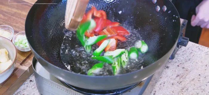Stir-fry green and red peppers for 10 seconds.