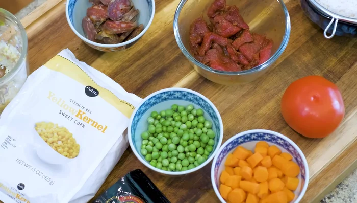 Arrange your favorite ingredients (peas, corn, carrots, ham, sausage, beef, etc.) around the tomato.