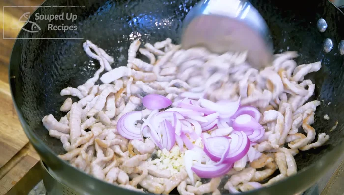 Add minced ginger, garlic, and shallot slices; stir until fragrant. Add julienned red chili.
