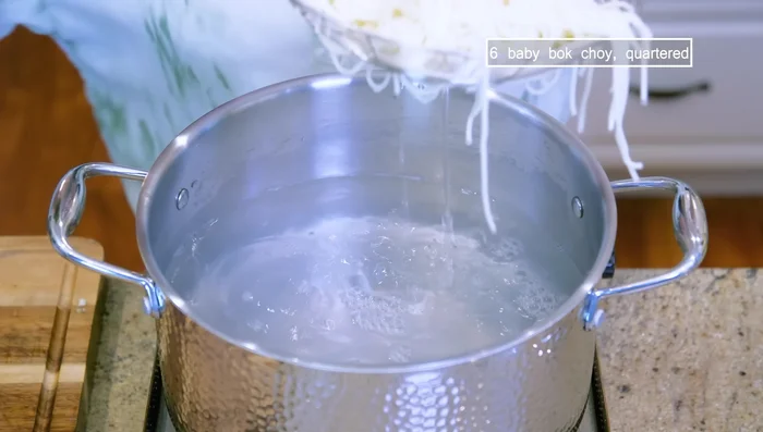 Blanch baby bok choy in boiling water.