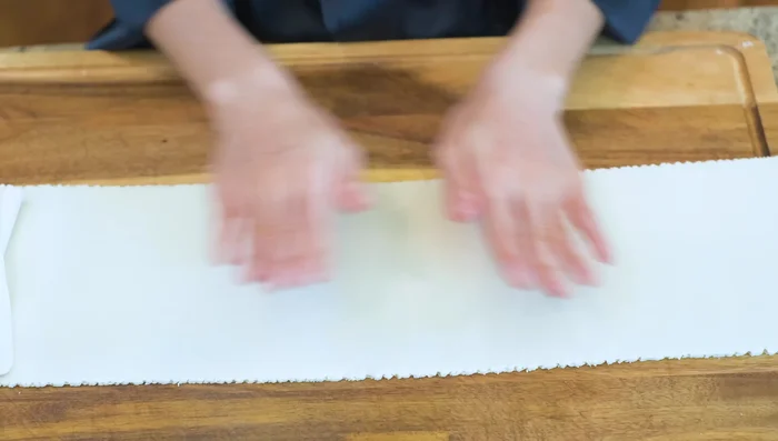 Lightly wet one half of the dough sheet, fold it over, and press to remove air bubbles. Dust with cornstarch to prevent sticking and cover with plastic wrap. Let rest for 10 minutes.