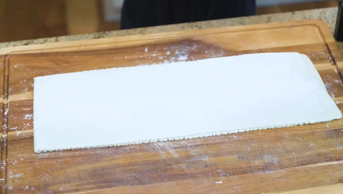 Roll the rested dough again to a thinner sheet (1/5 inch thick). Cut into noodles.