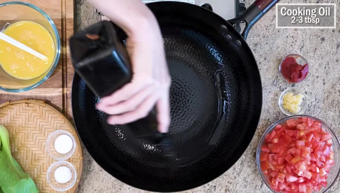 Heat wok on high, add cooking oil, swirl to create a non-stick layer.