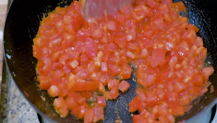 Season with sugar and salt. Stir over low heat until tomatoes are soft and release juice.