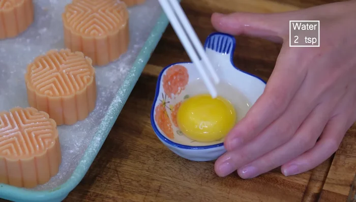 Preheat oven to 360°F (182°C). Brush mooncakes with egg wash (egg yolk and water).