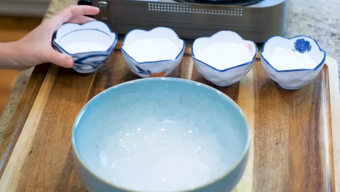 Prepare the wrapper: Combine 50g sugar, 50g glutinous rice flour, 50g rice flour, 35g wheat starch, and the remaining coconut milk in a bowl. Mix well.
