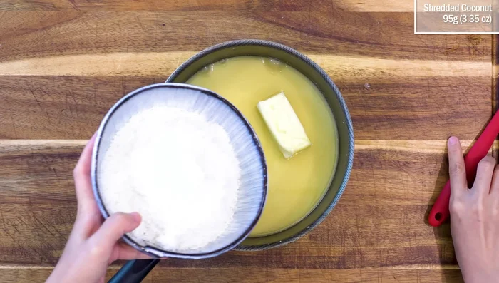 Add 4.5 tbsp butter and 95g shredded coconut. Stir constantly over low heat until the mixture thickens (about 10 minutes).