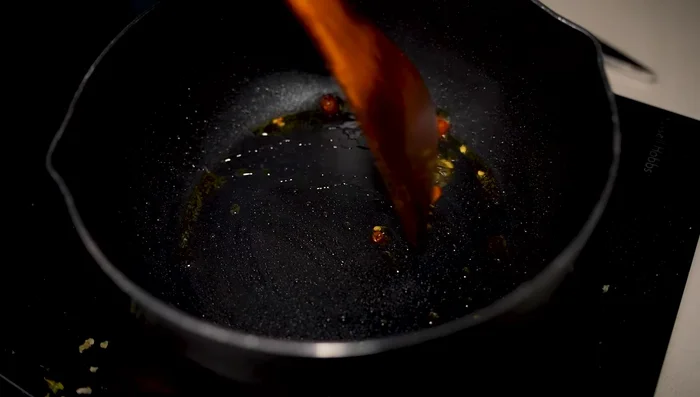 Prepare the sweet and sour sauce: Heat olive oil in a pan. Add chopped chili and stir-fry until fragrant. Add crushed garlic and ginger, then add water, white vinegar, Chinese rock sugar, and tomato sauce. Stir until the sugar melts and the sauce thickens. Season with salt.