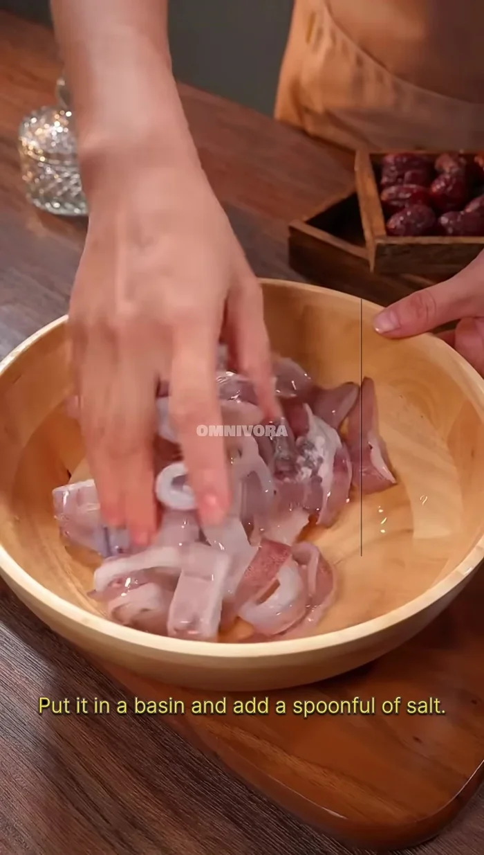 Cut squid into larger rings. Put in a basin, add a spoonful of salt, rub and mix to clean off surface mud and liquid.