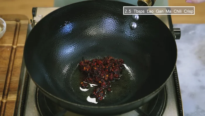 Pour out oil. Sauté Laama chili crisp, minced garlic, and ginger until fragrant.