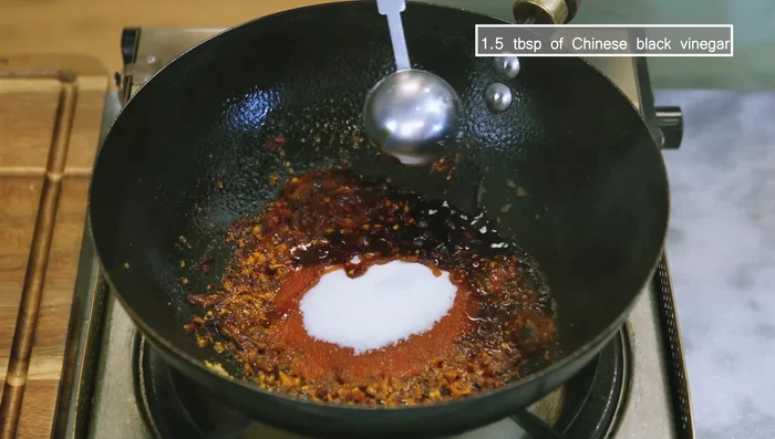 Add sugar, Chinese black vinegar, and soy sauce. Stir. Mix cornstarch and water, pour into wok, and stir until sauce thickens.