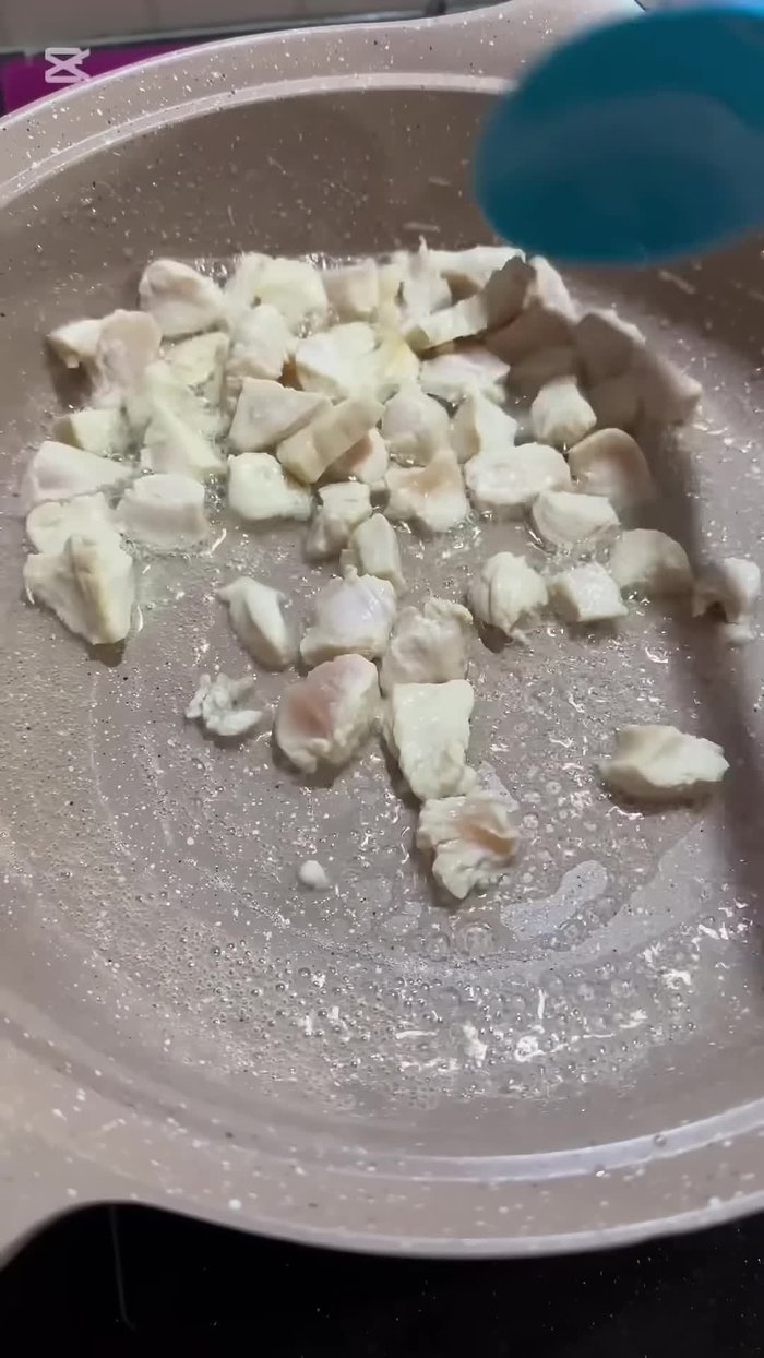 Cut chicken into cubes and put it in cooking oil. The cooking oil shouldn't be too hot to prevent sticking.