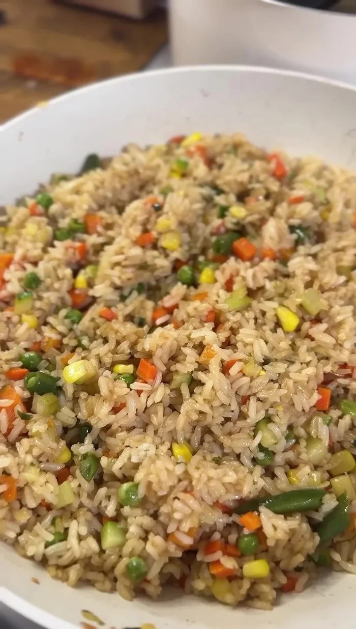 Combine the cooked rice with the stir-fried vegetables and sauces.